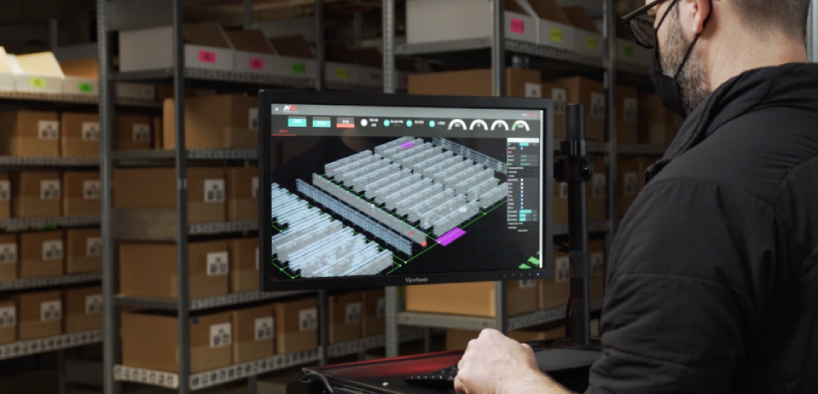 Warehouse Worker Reviewing Warehouse Logistics On Computer Monitor