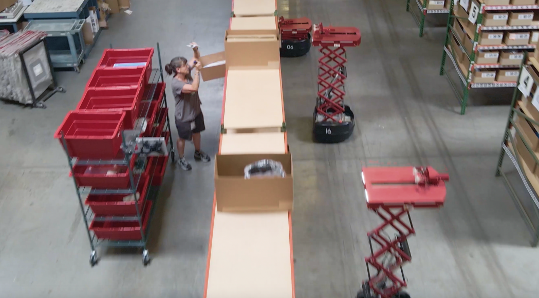 AMR Robots Dropping Off Goods In Modern Warehouse